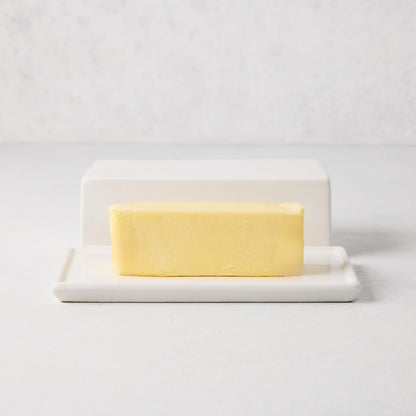 White ceramic HG butter dish with lid and a stick of European butter.