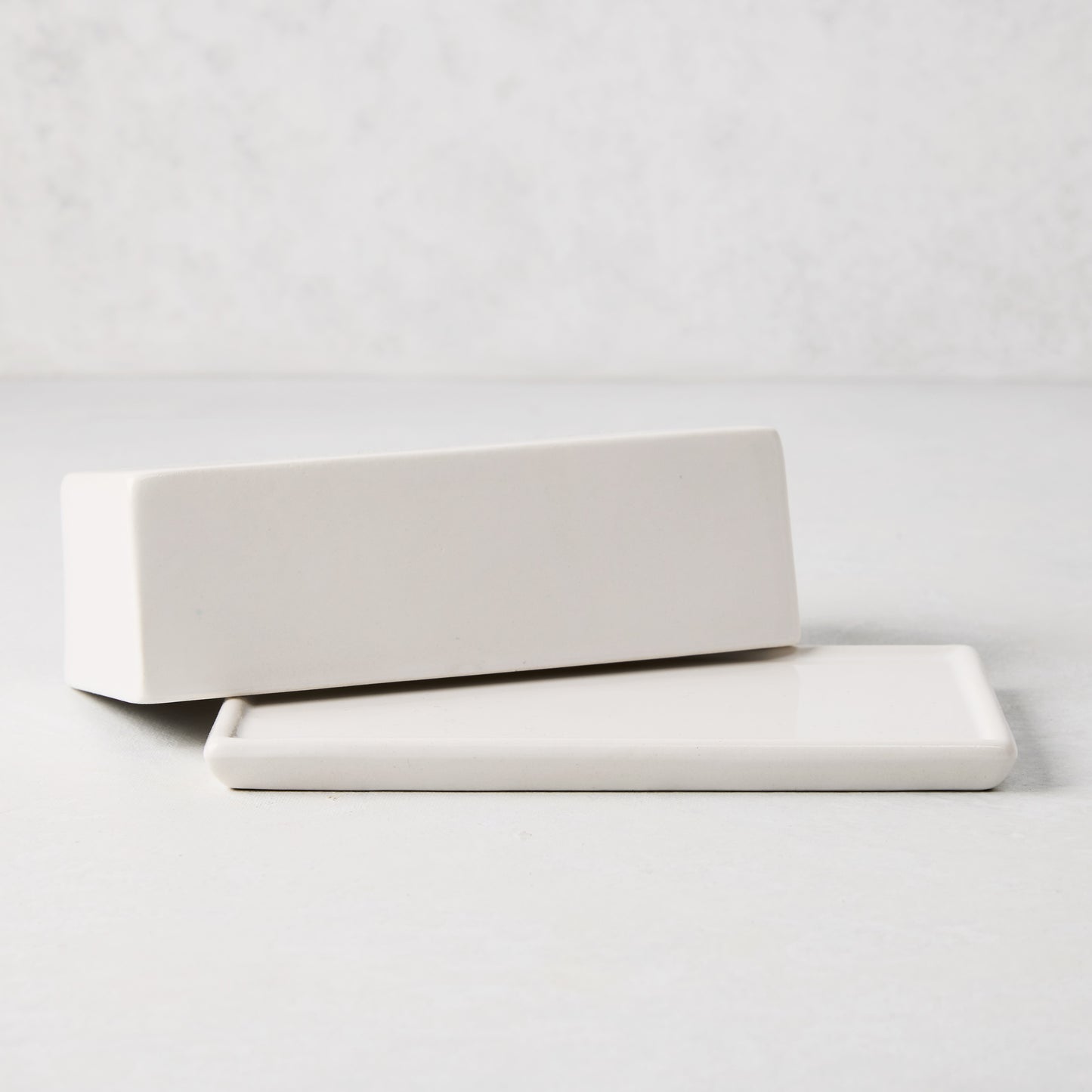 White ceramic butter dish with a rectangular lid resting on its base.