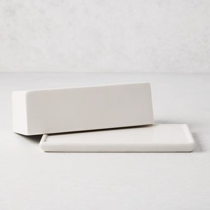 White ceramic butter dish with a rectangular lid resting on its base.