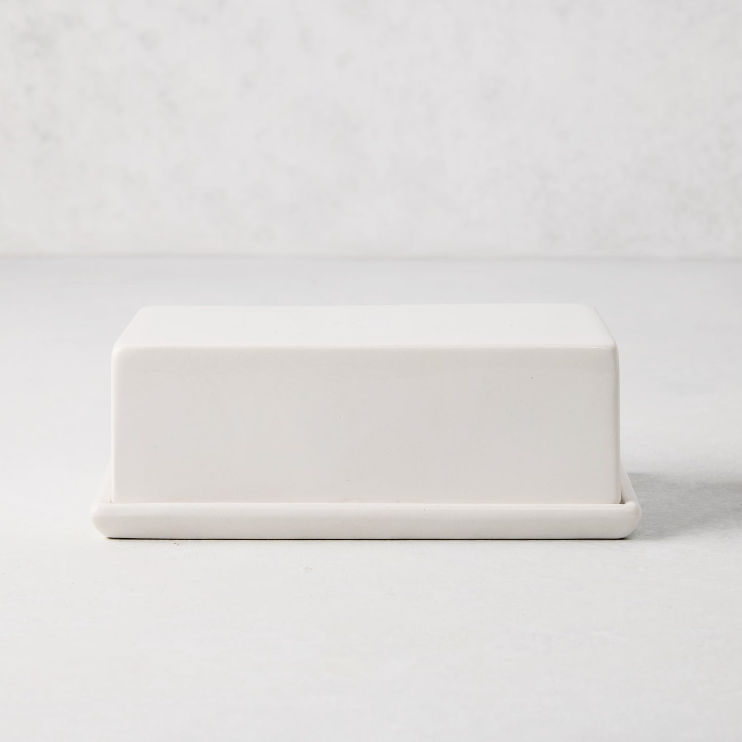 White ceramic butter dish with a sleek rectangular lid and tray.