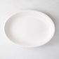 White ceramic deep serving platter, 14"W x 20"L, with high rolled edge.