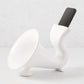 White ceramic kitchen speaker with a smartphone docked in the top opening.