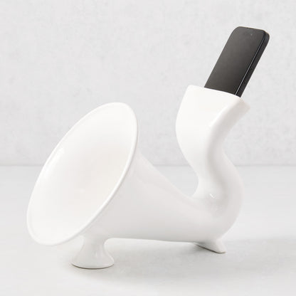 White ceramic kitchen speaker with a smartphone docked in the top opening.