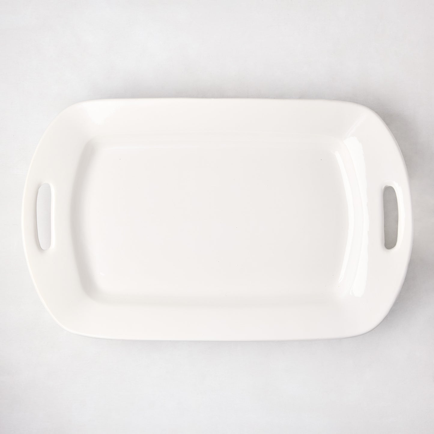 White ceramic serving platter with elegant handles, 13"W x 21"L, high-fired earthenware.