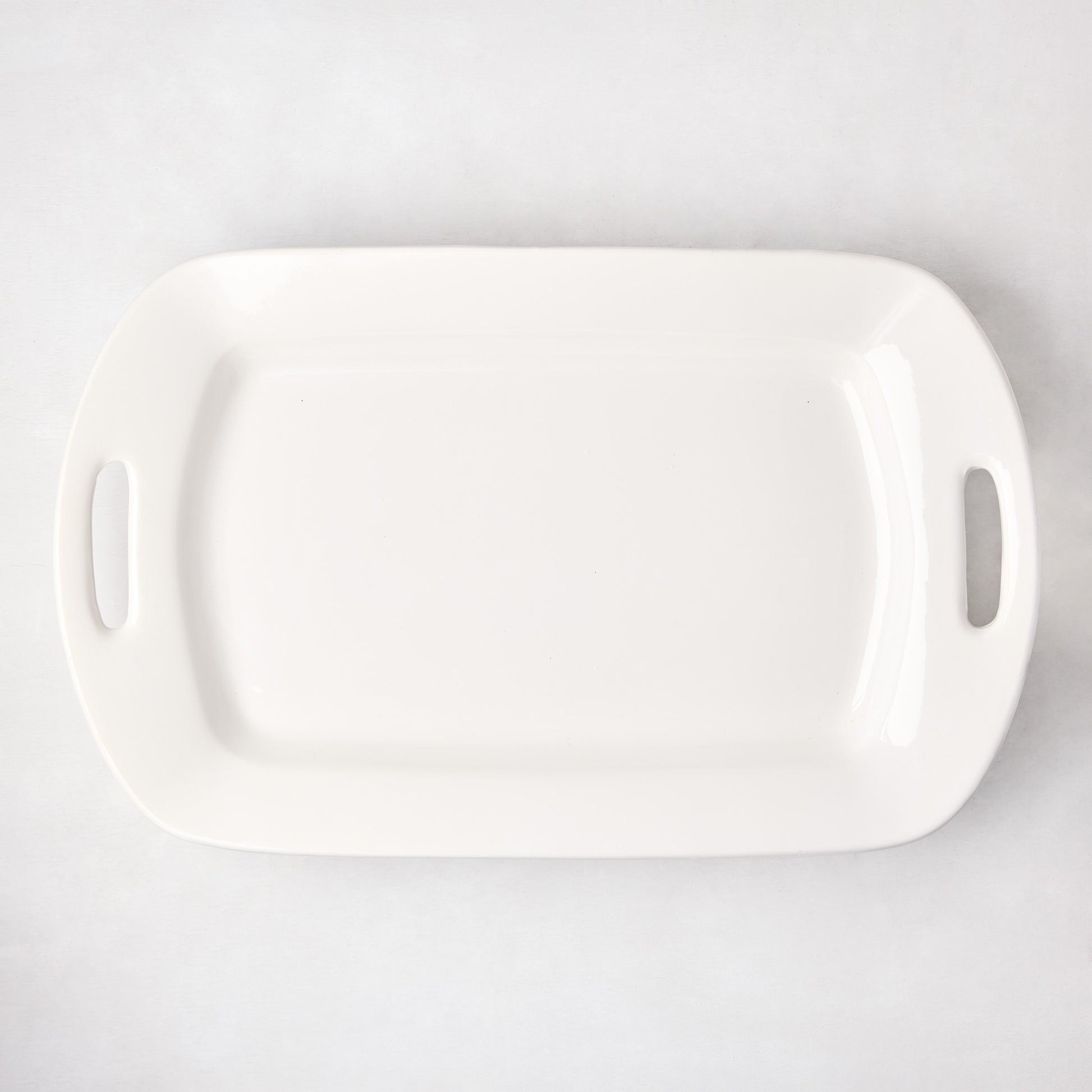 White ceramic serving platter with elegant handles, 13"W x 21"L, high-fired earthenware.