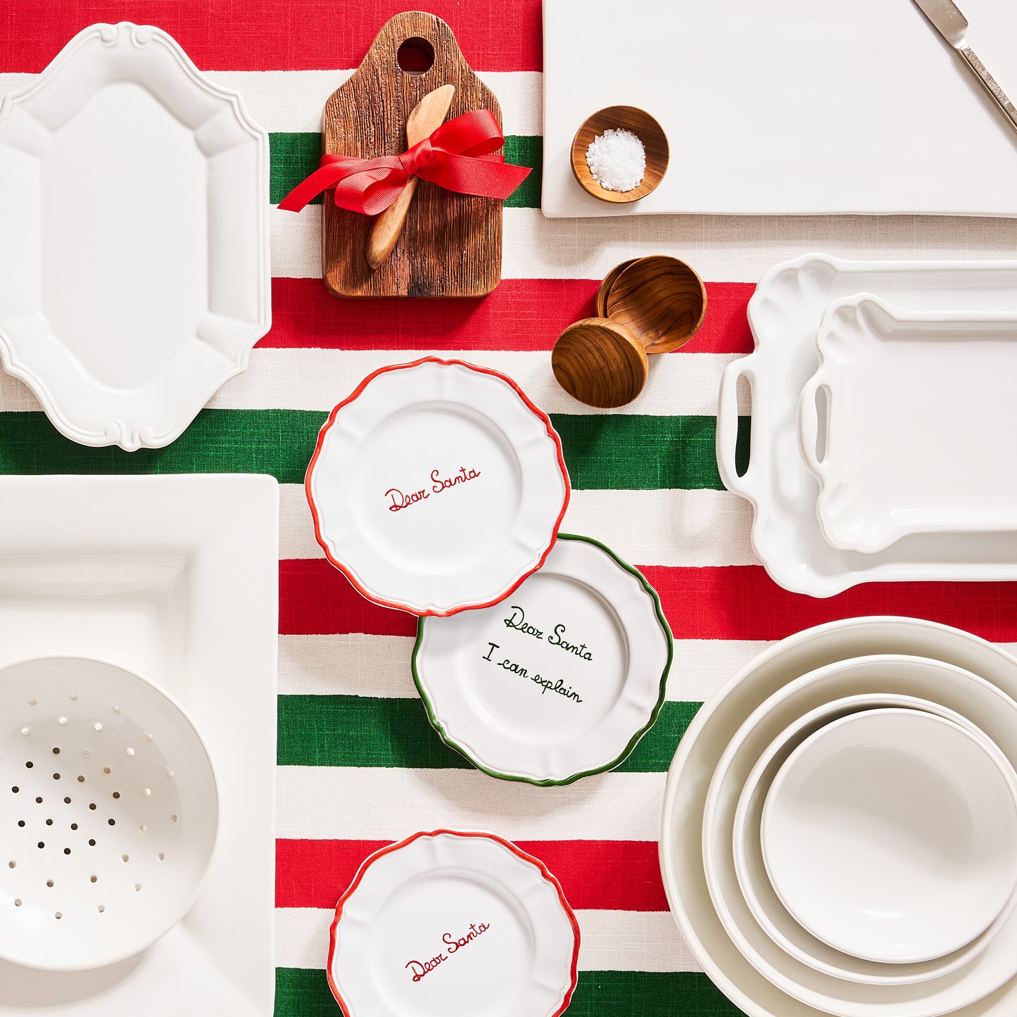 White ceramic nesting serve bowls, set of 4, on a striped tablecloth.