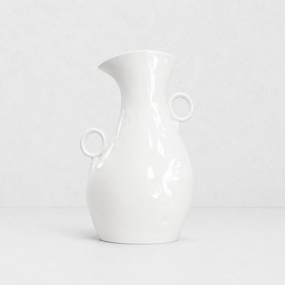 Creamy white ceramic pitcher by Montes Doggett, 14"H, with two round handles and a spout.