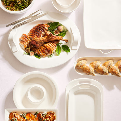 White ceramic handled serving platter with roasted turkey, figs, and rosemary.