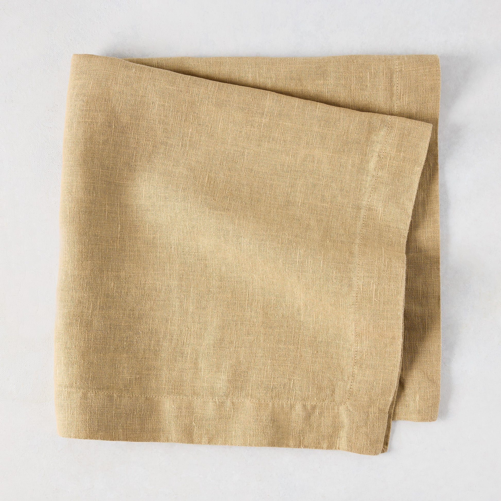 Chai HG Signature hand-dyed linen napkin, 22-inch square, creamy nutmeg color, folded.