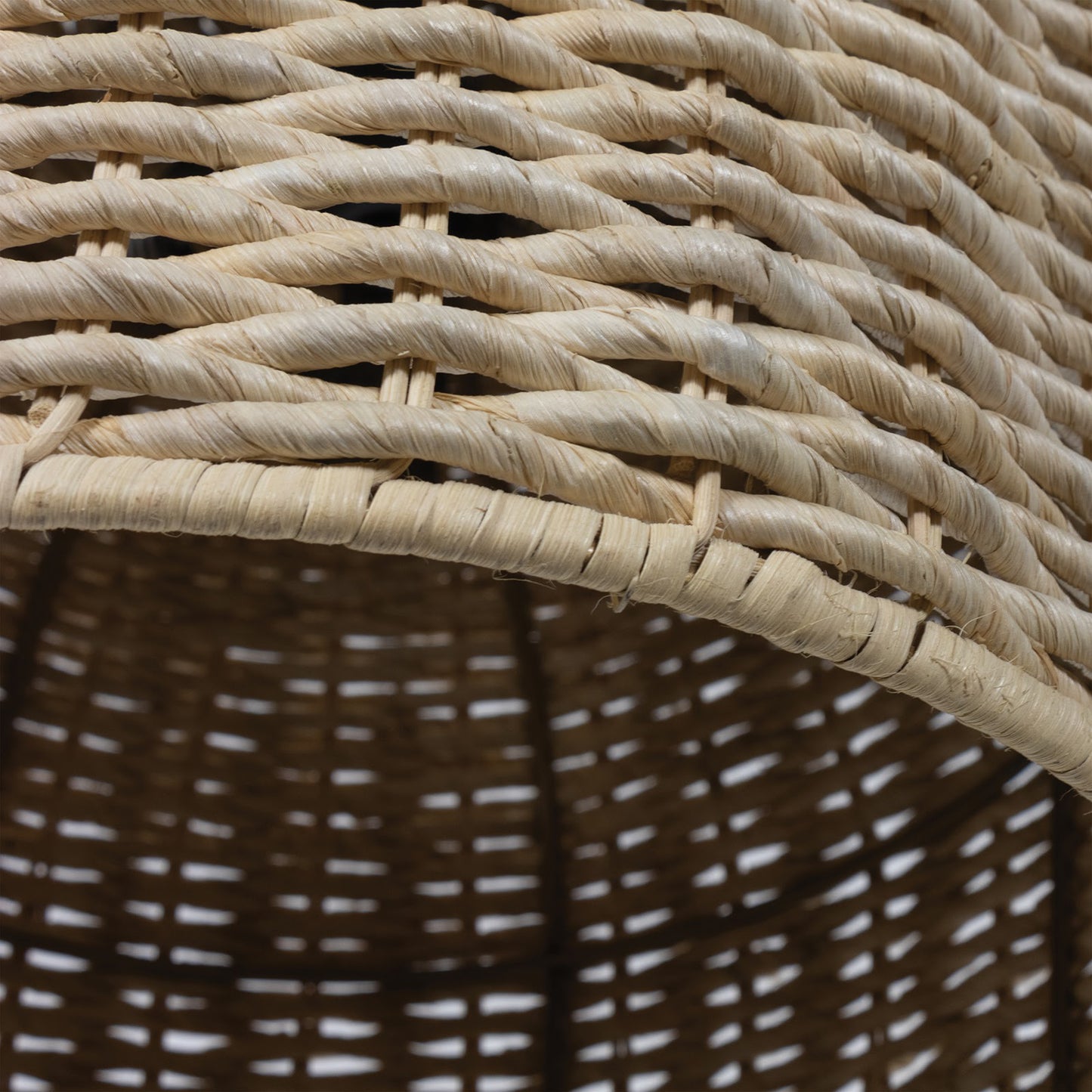 Close-up of a dome-shaped Champagna pendant light shade made of natural rattan-like material.