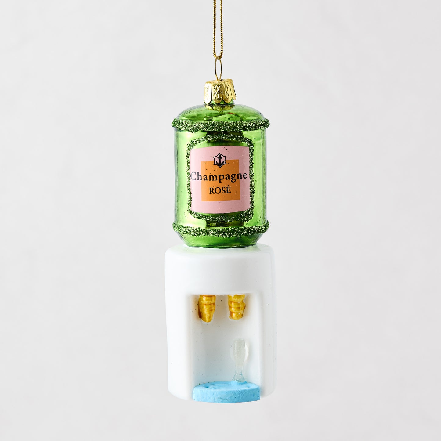 Mouth-blown glass and resin champagne cooler ornament with green bottle, pink label, and white water dispenser base.