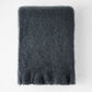 Charcoal gray solid mohair throw blanket with a thick, fuzzy texture and fringed edges on a white background.