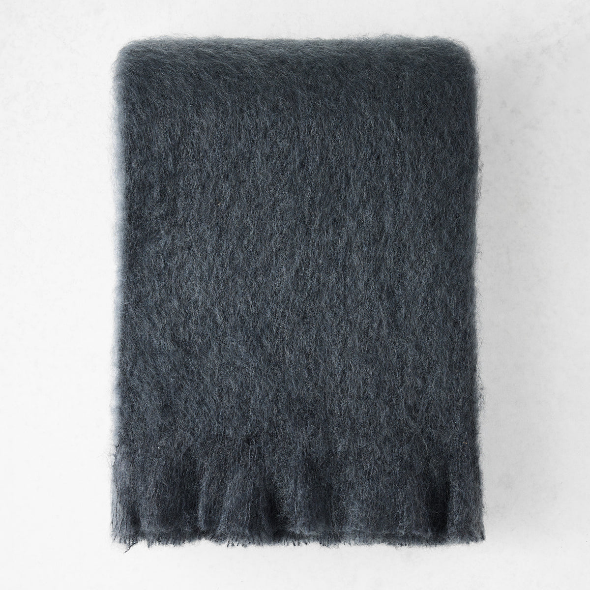 Charcoal gray solid mohair throw blanket with a thick, fuzzy texture and fringed edges on a white background.