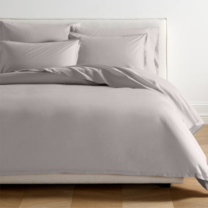 Charcoal grey Italian percale duvet set with two shams on a bed, showing crisp, smooth fabric.
