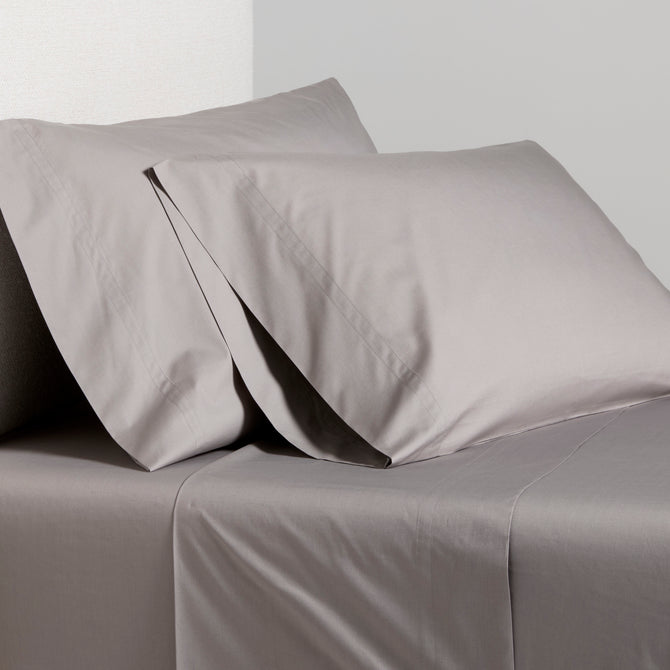 Charcoal Grey Italian Percale Sheet Set with two pillowcases on a bed.