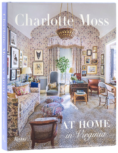 Charlotte Moss: At Home in Virginia coffee table book featuring a floral-patterned living room with animal print carpet.