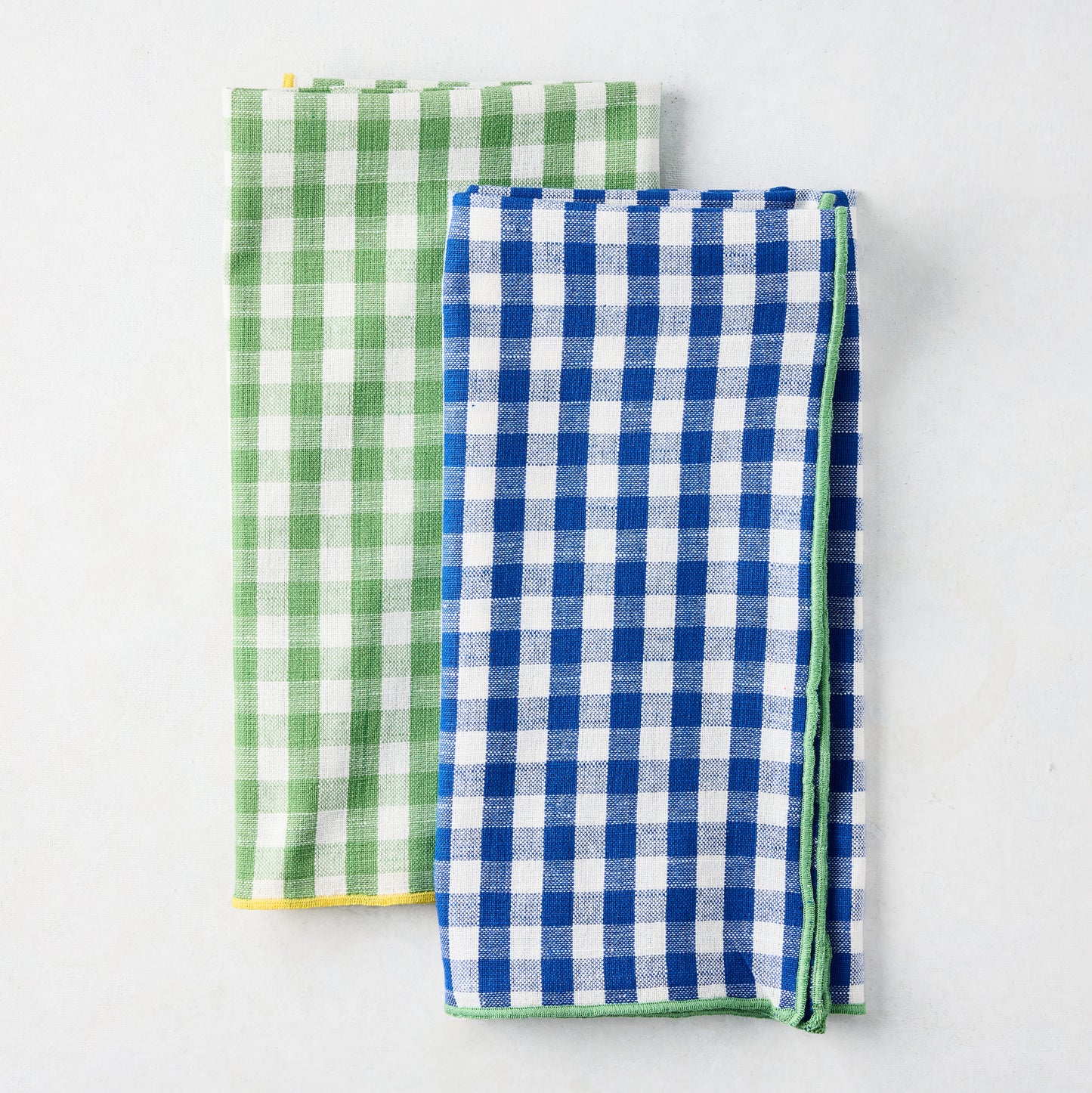 Chatham Blue Gingham Cotton Napkin with Green Trim, folded next to a green gingham napkin.