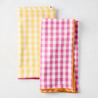 Chatham Yellow Gingham Cotton Napkin with Pink Trim, folded, next to a pink gingham napkin.