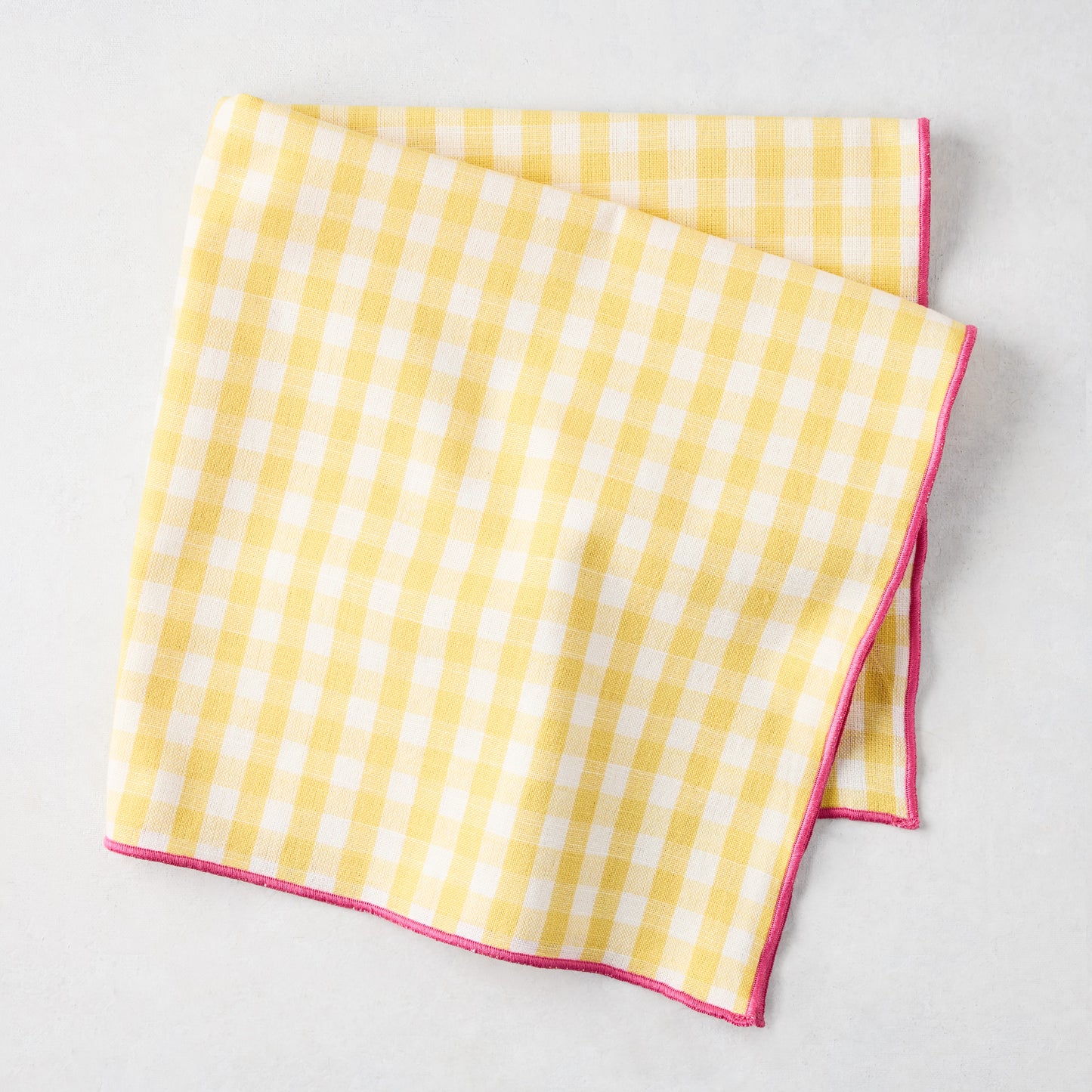 Chatham Yellow Gingham Cotton Napkin with Pink Trim, 22" square, folded.