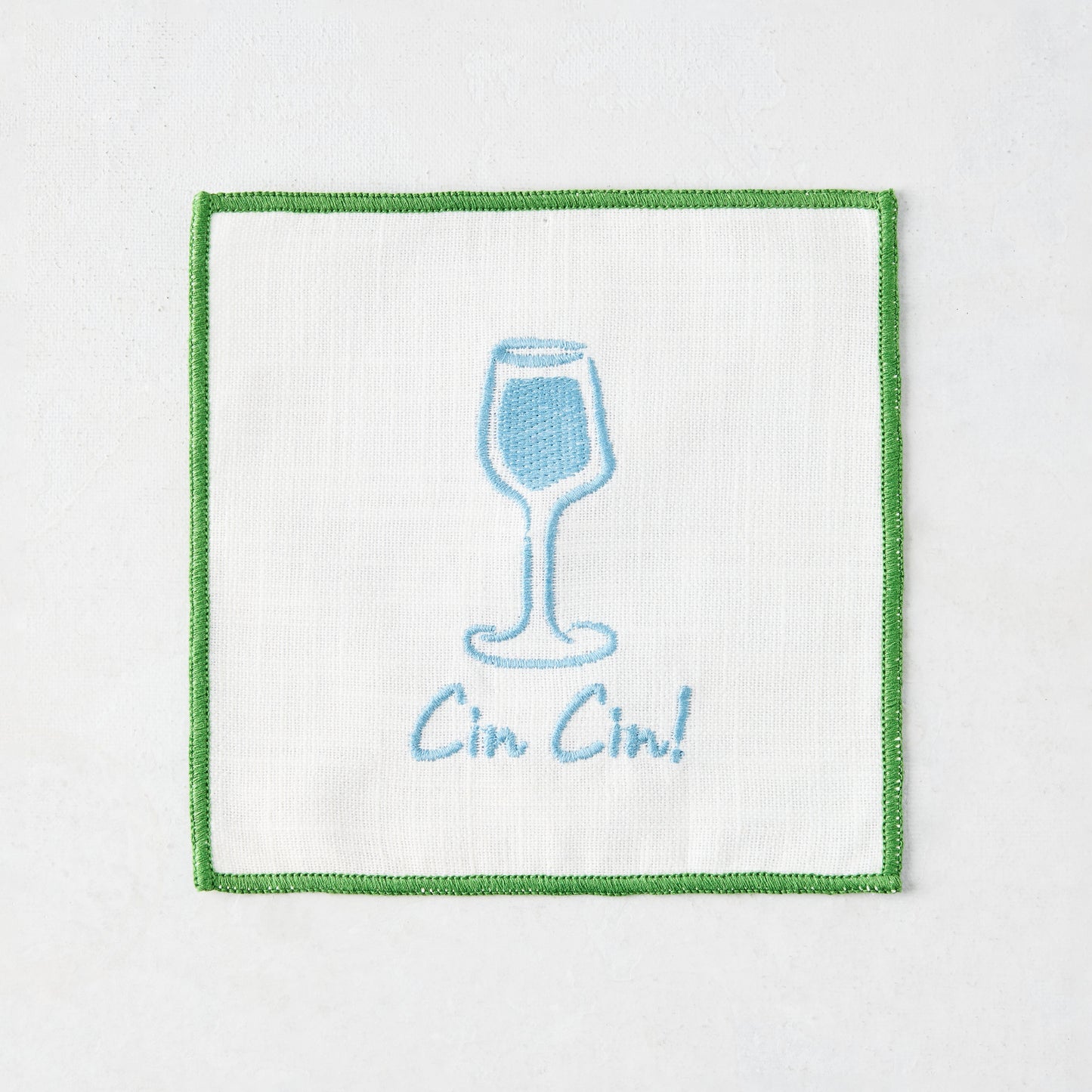 White cotton coaster with blue embroidered cocktail glass and "Cin Cin!" text, green border.
