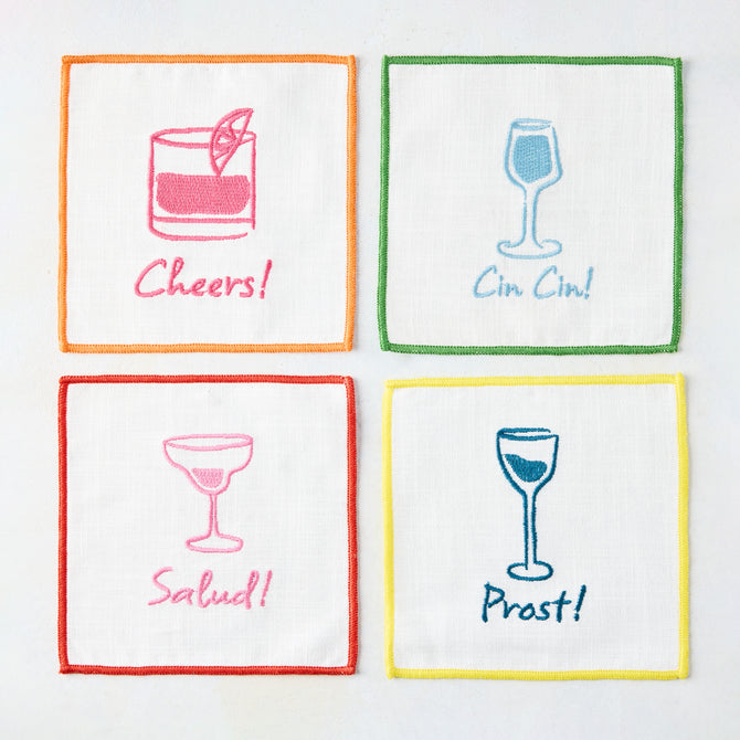 Set of 4 white cotton "Cheers" embroidered coasters with colorful cocktail designs and greetings.