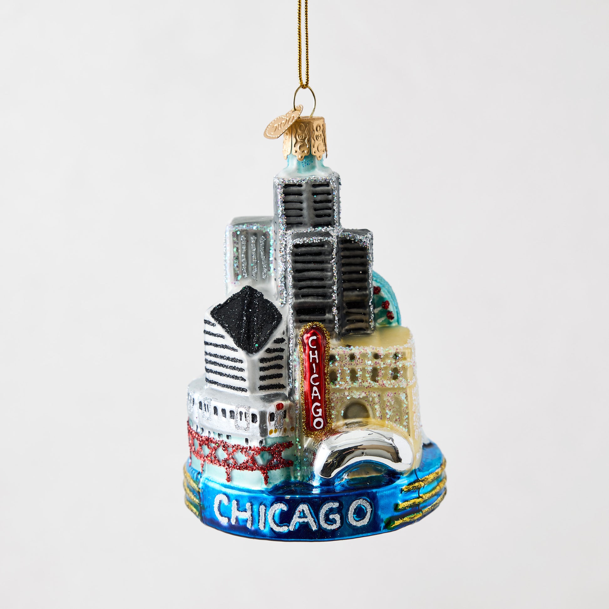 Hand-painted glass and resin Chicago skyline Christmas ornament with glitter accents and a blue base.