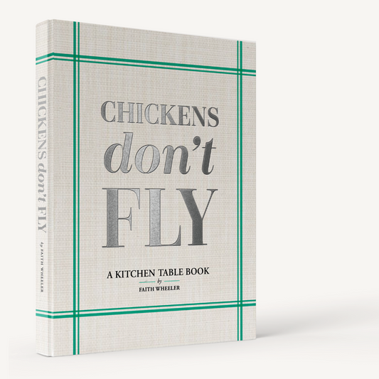 Hardcover "Chickens Don't Fly" cookbook with a textured cream cover, green border, and silver title text.