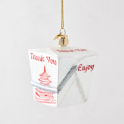 Hand-painted white glass Chinese takeout box ornament with red pagoda design, glitter accents, and gold hanging string.