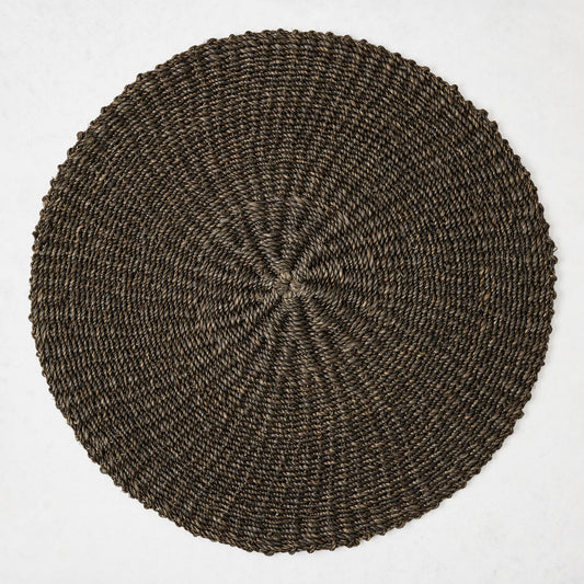 16-inch round placemat hand-woven from chocolate brown abaca fiber with a textured spiral pattern.