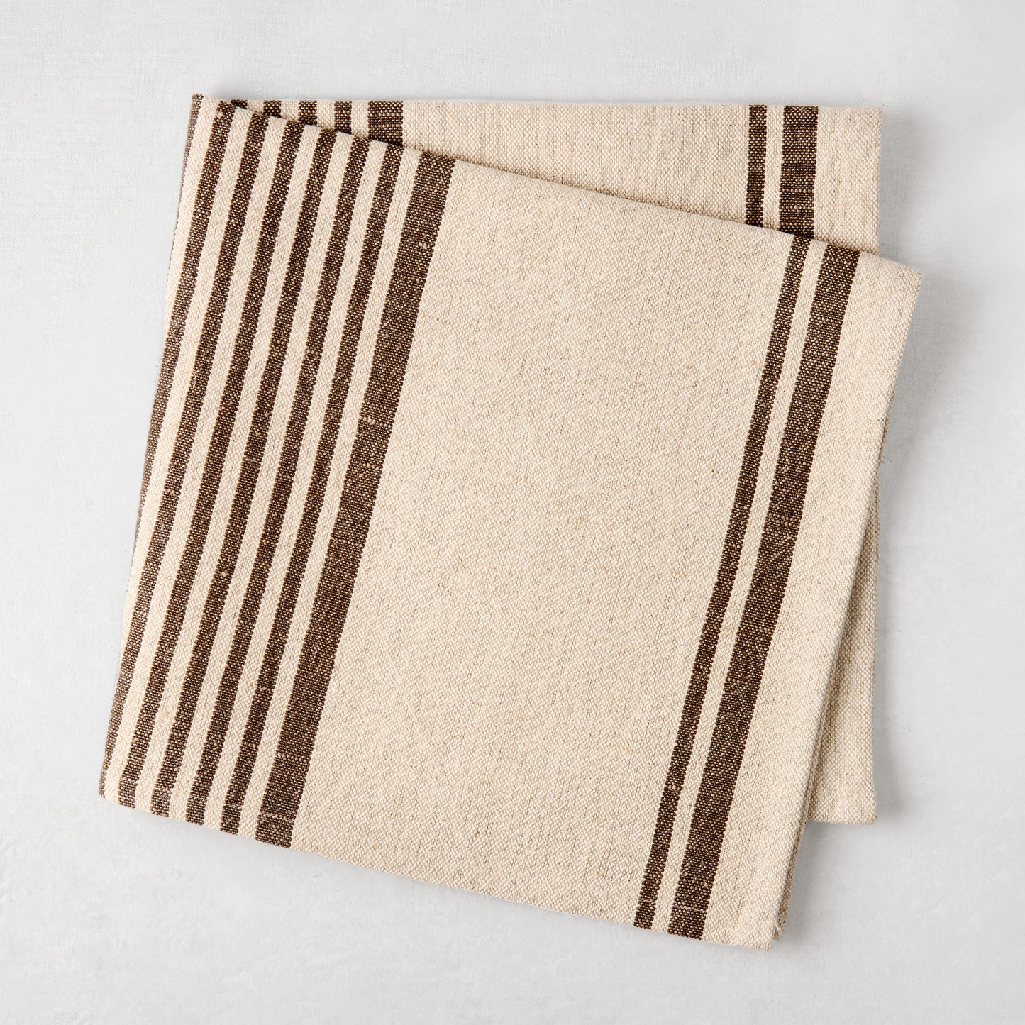 Folded natural beige and chocolate brown boat stripe cotton linen napkin.