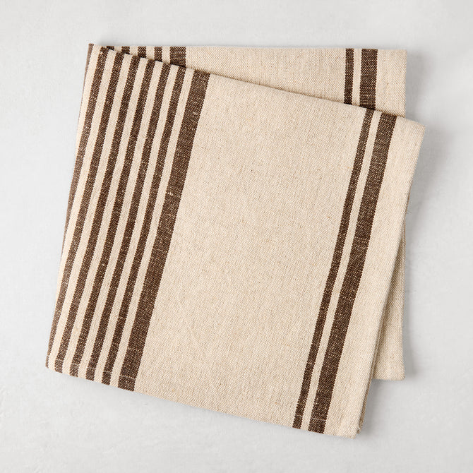 Folded natural beige and chocolate brown boat stripe cotton linen napkin.