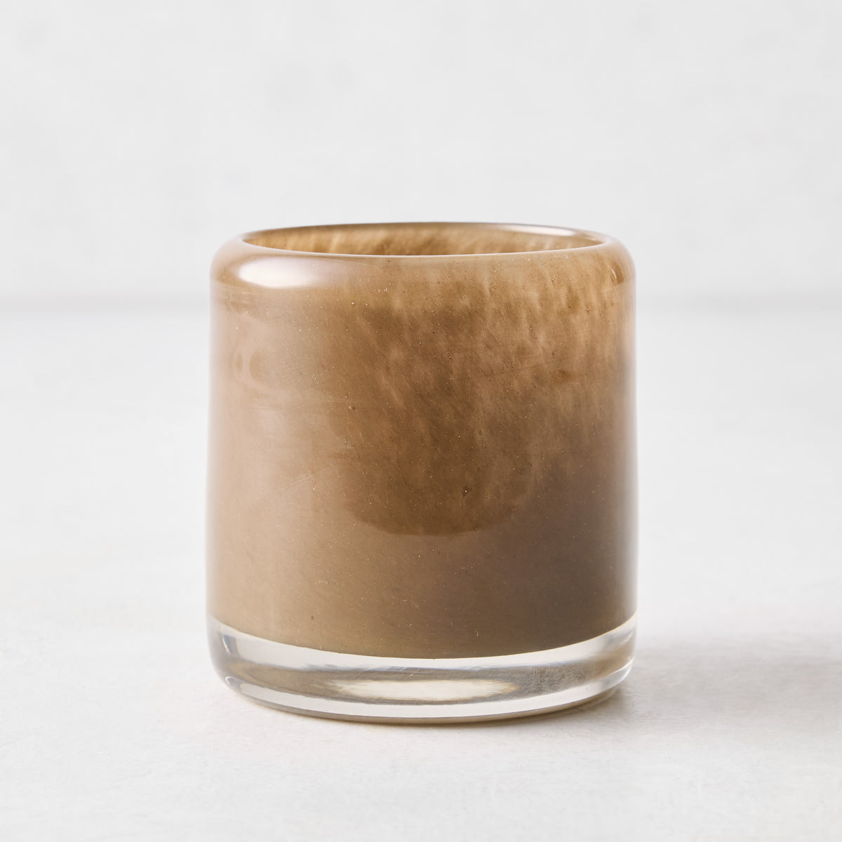 Small mouth-blown chocolate brown glass votive candle holder, 2.75 inches tall with a translucent, swirling finish.