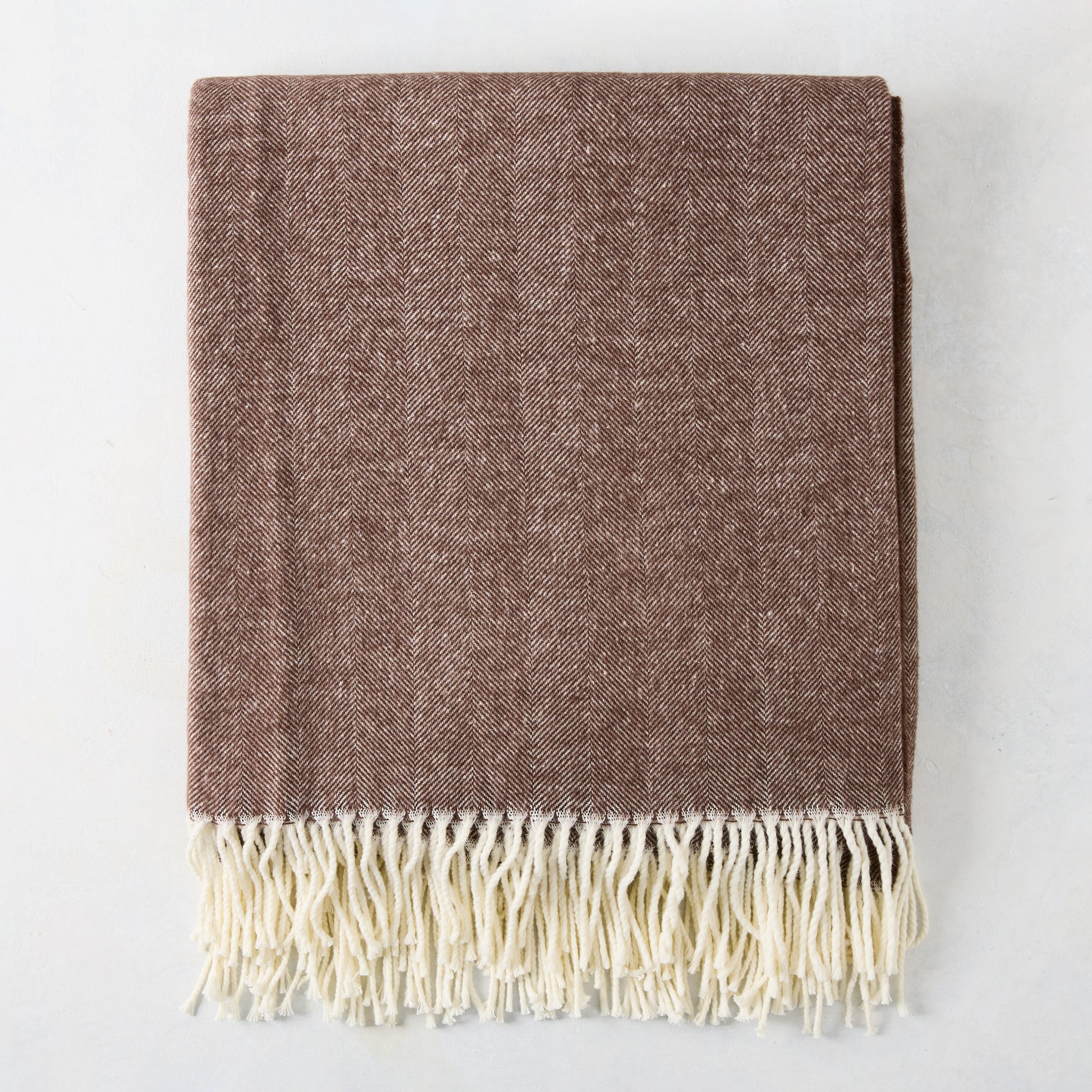Chocolate brown Italian herringbone throw blanket with cream fringe.