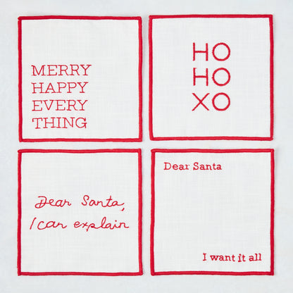 Set of four 5.5-inch square white cotton coasters with red embroidered Christmas phrases and red stitched borders.