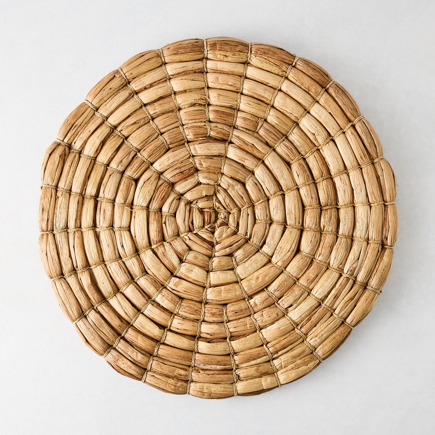 Chunky natural seagrass round woven placemat, 16", with a thick, robust weave.