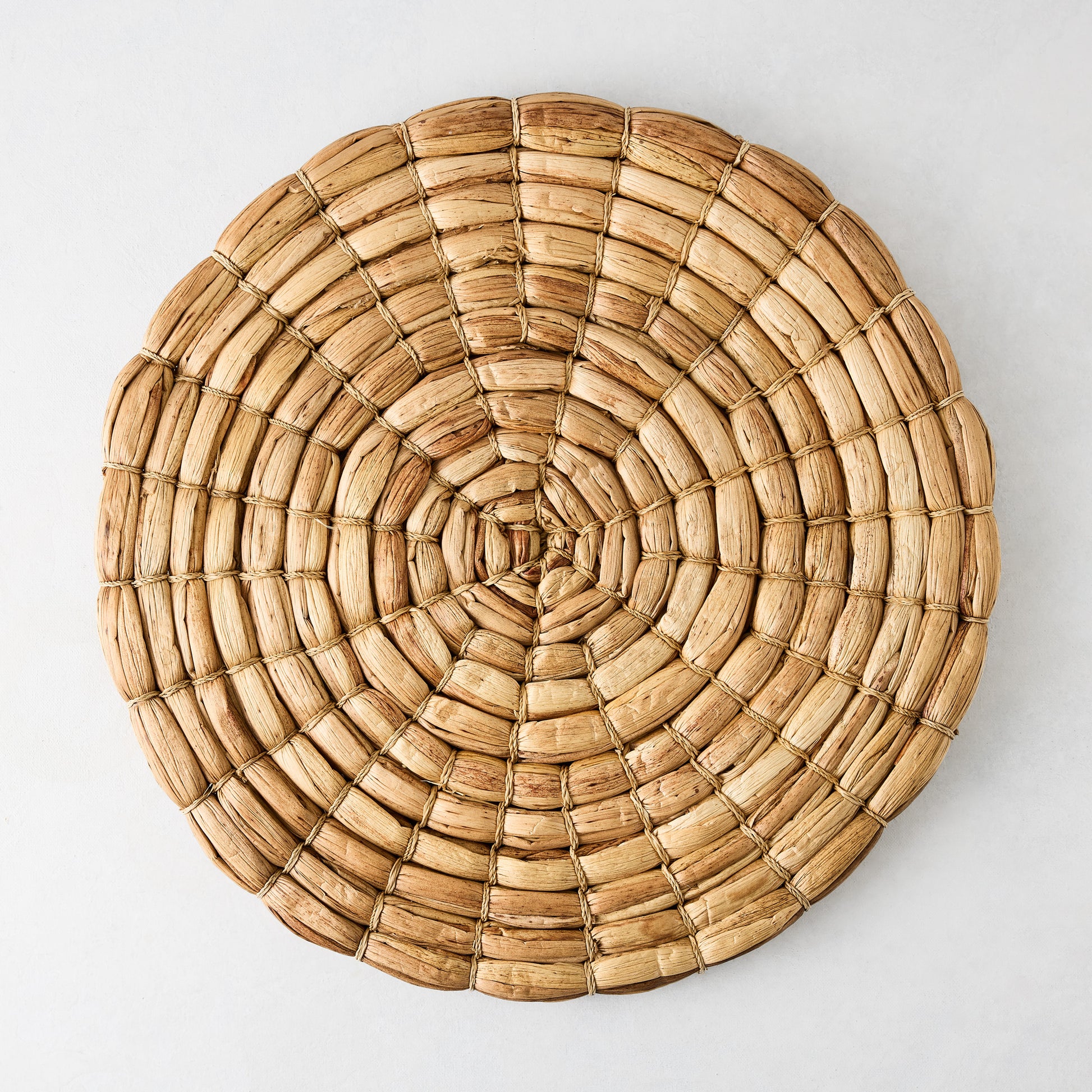 Chunky natural seagrass round woven placemat, 16", with a thick, robust weave.