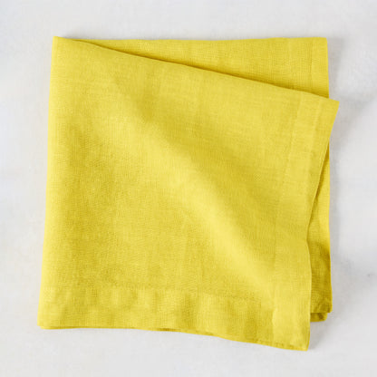 Citron HG Signature hand-dyed, folded lemon yellow linen napkin, 22-inch square.