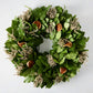 Green privet leaf wreath with dried orange slices and light-colored sprigs.