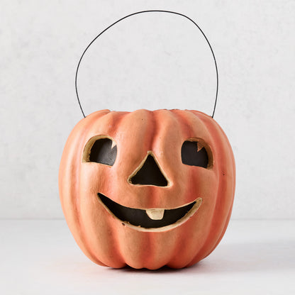 Handcrafted orange papier-mâché Jack O' Lantern candy bucket with distressed finish and wire handle.