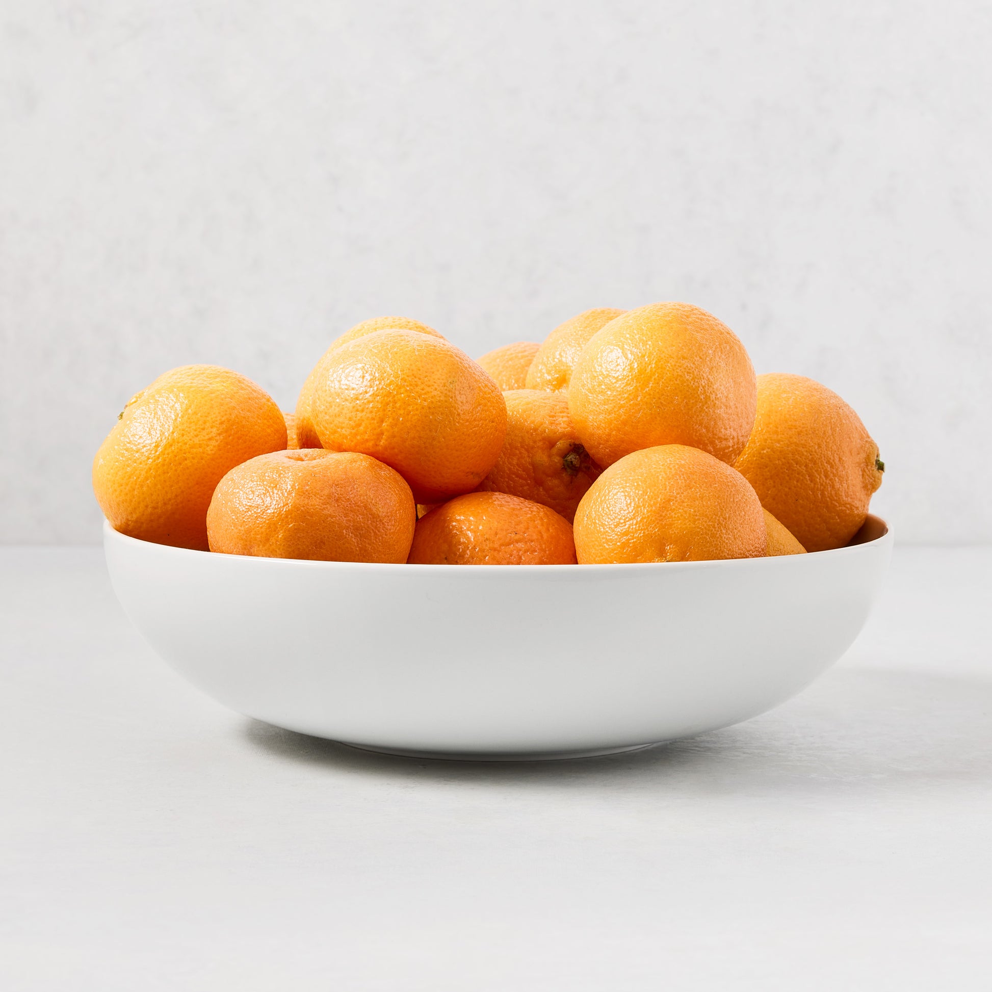 HG Classic Porcelain Serve Bowl, 10.5" diameter, filled with bright orange tangerines.