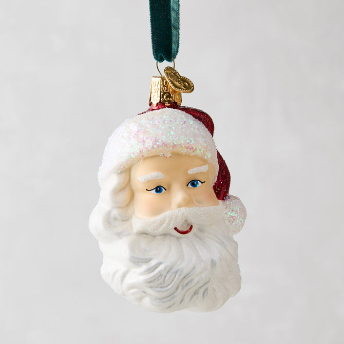 Glass Santa head Christmas tree ornament with glittery white beard, red hat, and blue eyes.