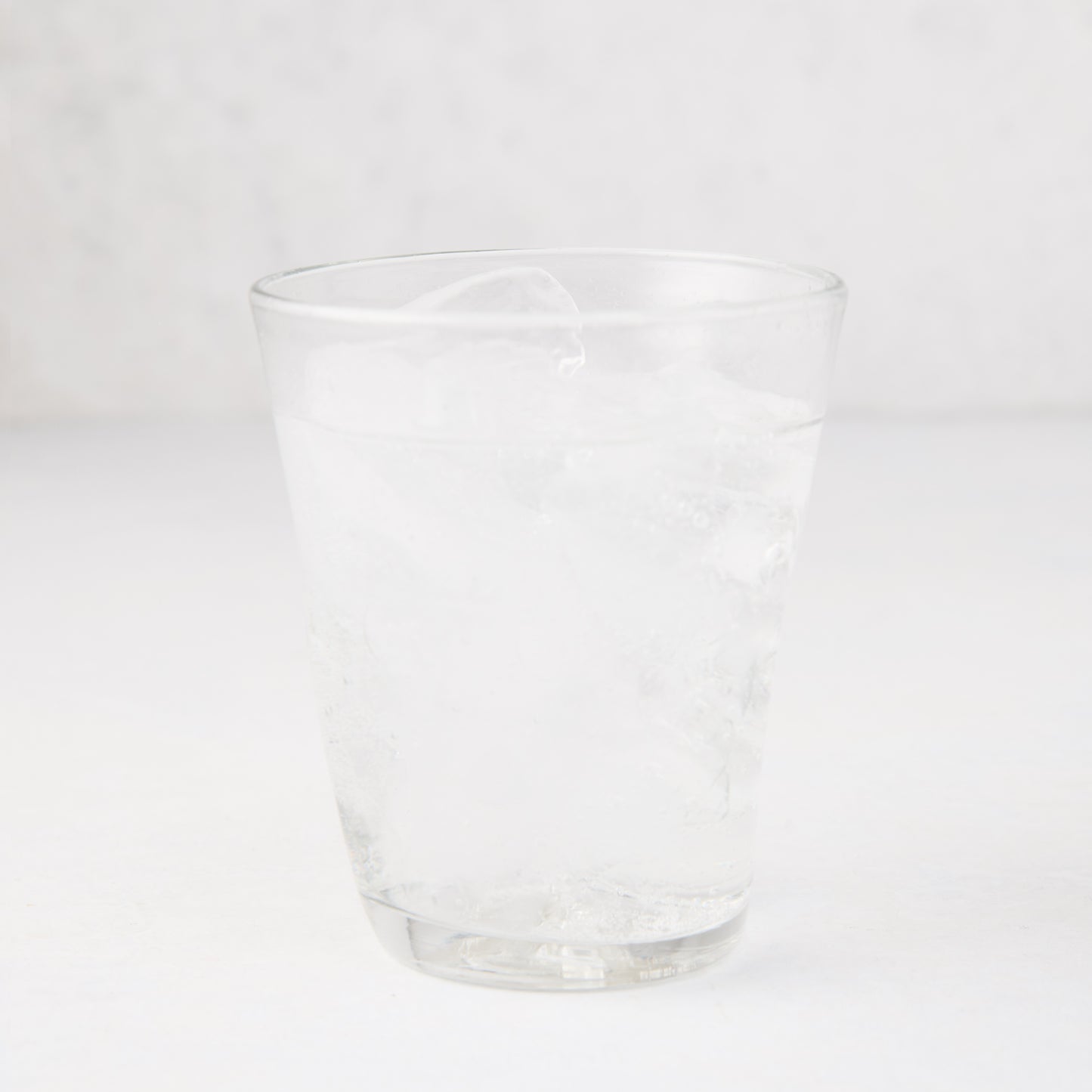 Clear Henri 8 oz. mouth-blown glass with ice and water, handmade.