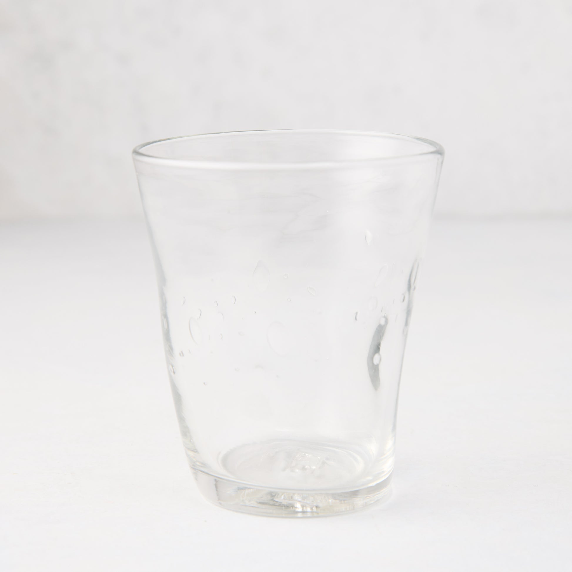 Clear Henri mouth-blown glass, 8 oz, with unique imperfections and small air bubbles.