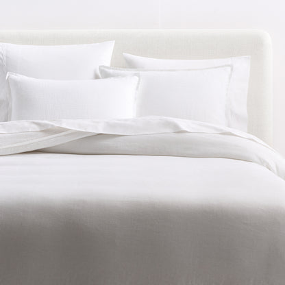 Cloud white European washed linen duvet cover and matching shams with a relaxed, soft texture on a bed.