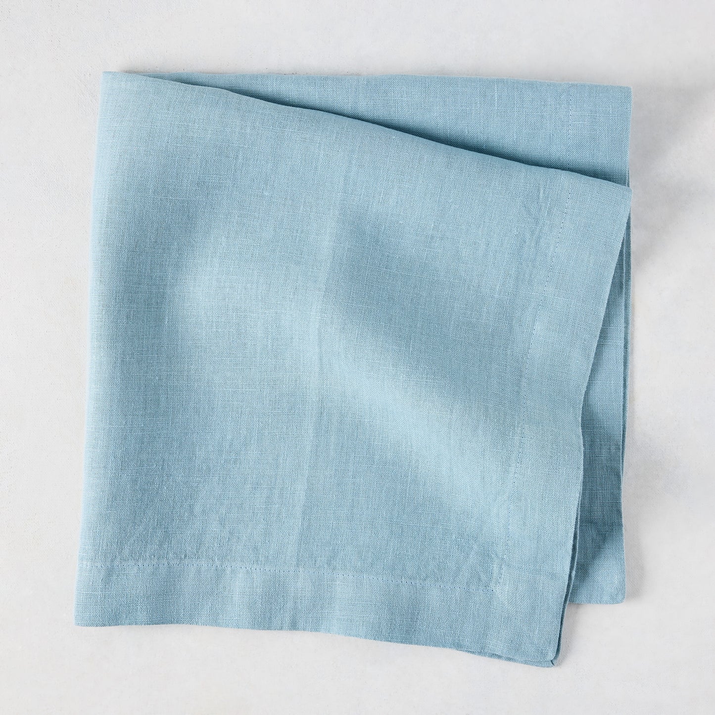 Cloudy HG Signature Hand-dyed Linen Napkin, folded, 22-inch square, muted blue-gray.