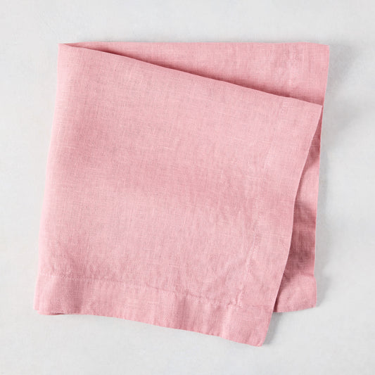 Clover Pink HG Signature hand-dyed linen napkin, 22-inch square, folded on a light surface.