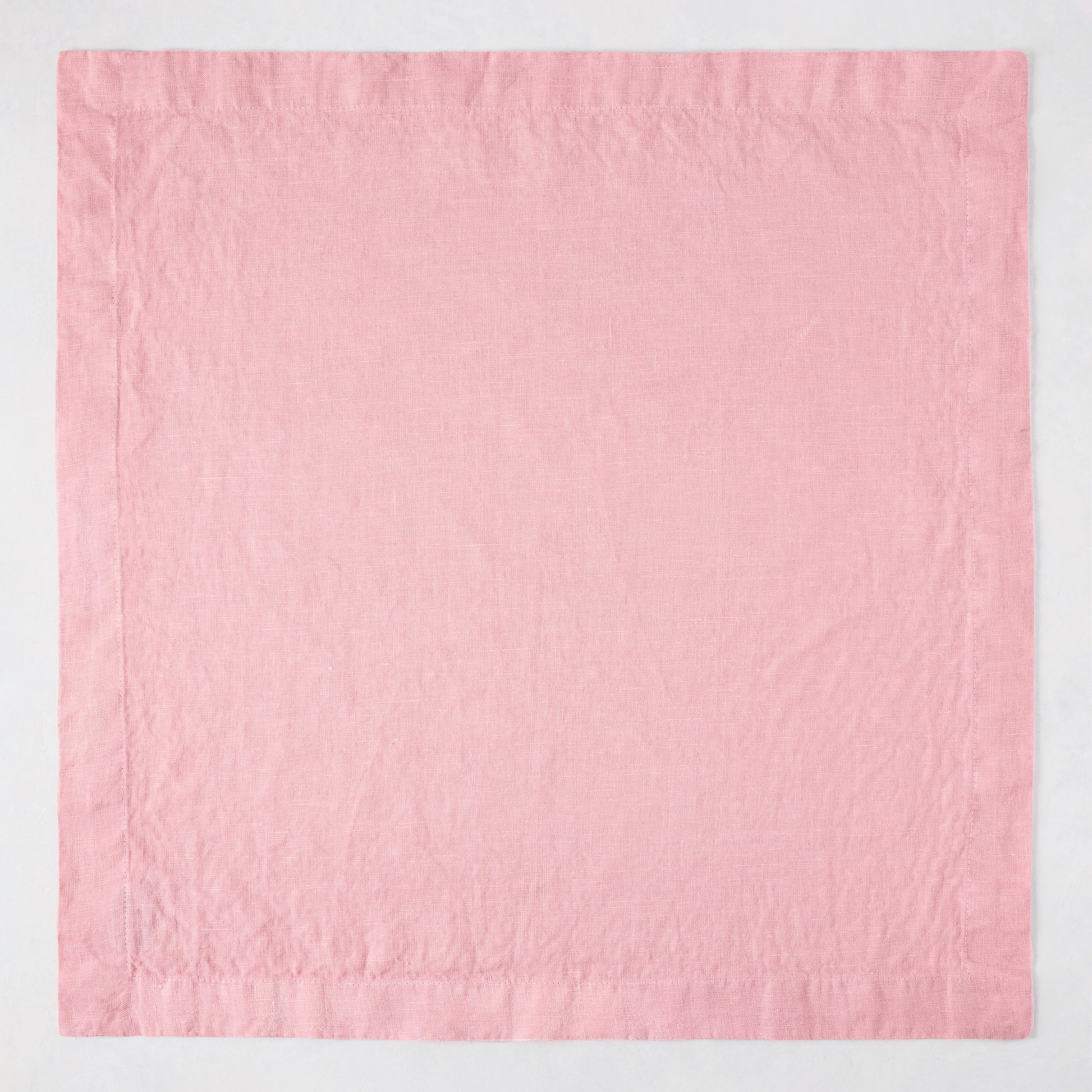 Clover Pink HG Signature hand-dyed 22-inch linen napkin with mitered corners, flat on a white surface.