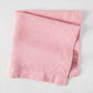 Clover Pink HG Signature hand-dyed linen napkin, 22-inch square, folded on a light surface.