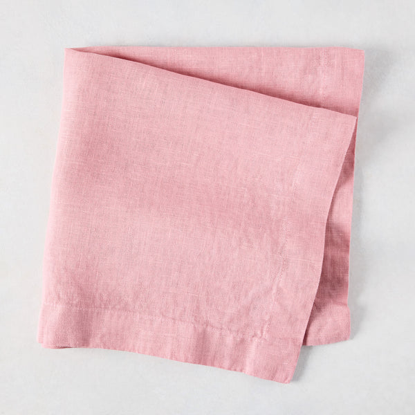 Clover Pink HG Signature hand-dyed linen napkin, 22-inch square, folded on a light surface.
