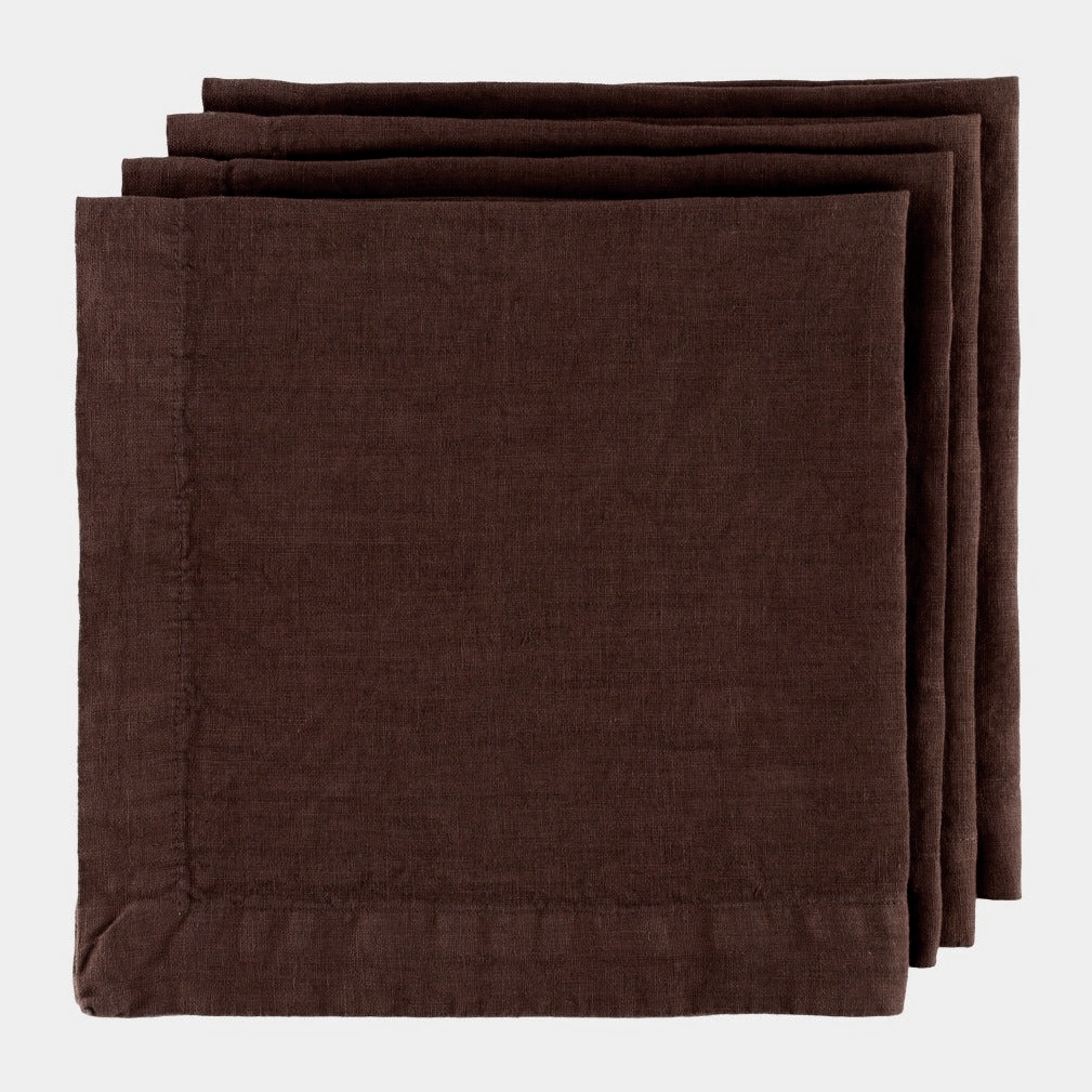 Stack of three folded Cocoa HG brown hand-dyed 22" linen napkins with mitered corners.